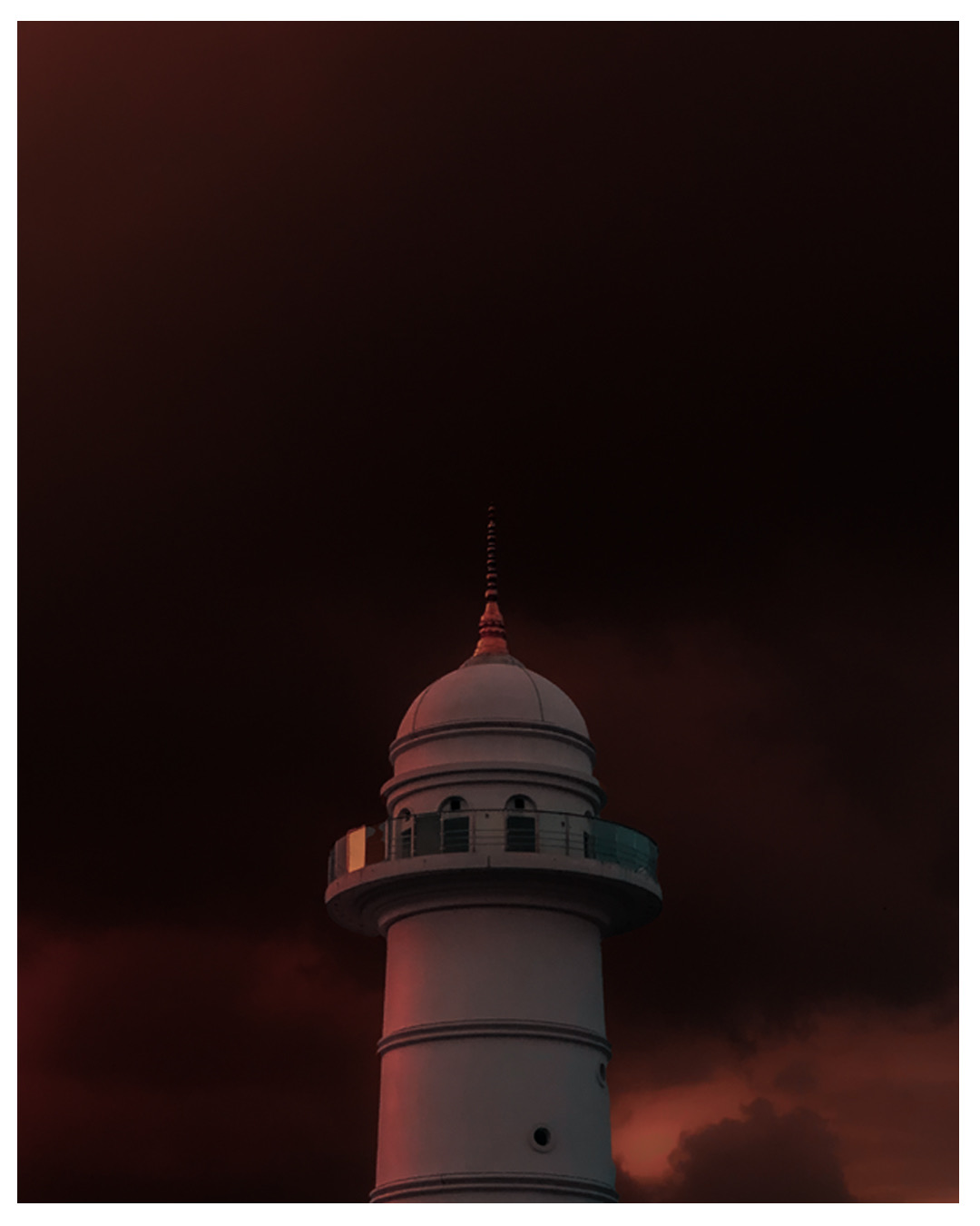 Temple architecture — dramatic night sky behind a white domed temple tower with moody red clouds